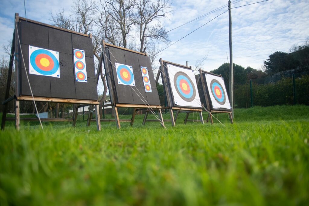 Archery targets on a lush green field outdoors, set for practice in Portugal.